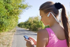 Girl with bluetooth wireless headphones for running